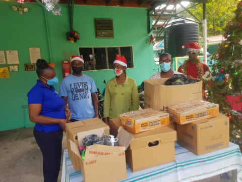 L-R. Sophie’s Place Administrator, Mrs. Christine Madden-Watson converses with NROCC employees, Mr. Marvin Reece and Ms. Patrean Roche while her colleague, Nurse Janice Nunes-Lorraine looks on during the handover of items donated by the company on Dec. 22, 2021.